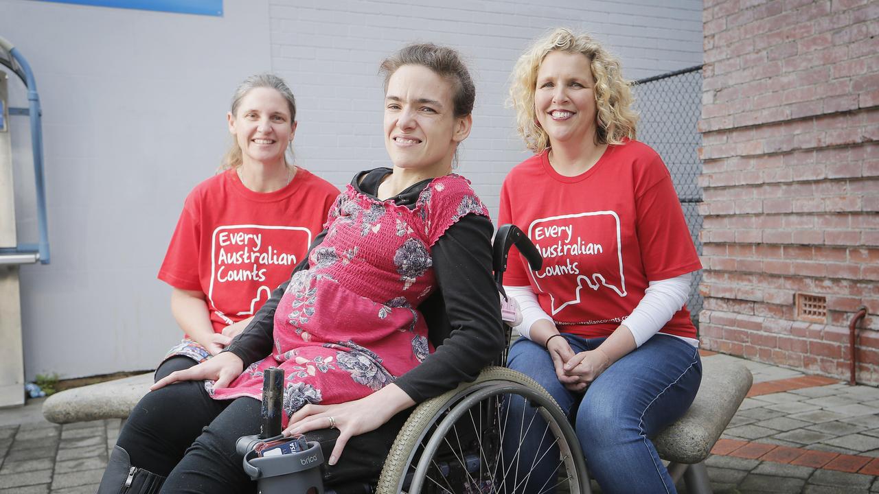 Three Every Australian Counts supporters sitting all wearing Every Australian Campaign T-shirts